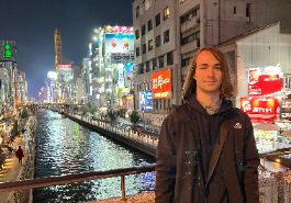  Ethan Gastmeier stands in front of revier in city of Osaka in Japan